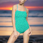 Aqua one piece swimsuit worn by model standing on the beach