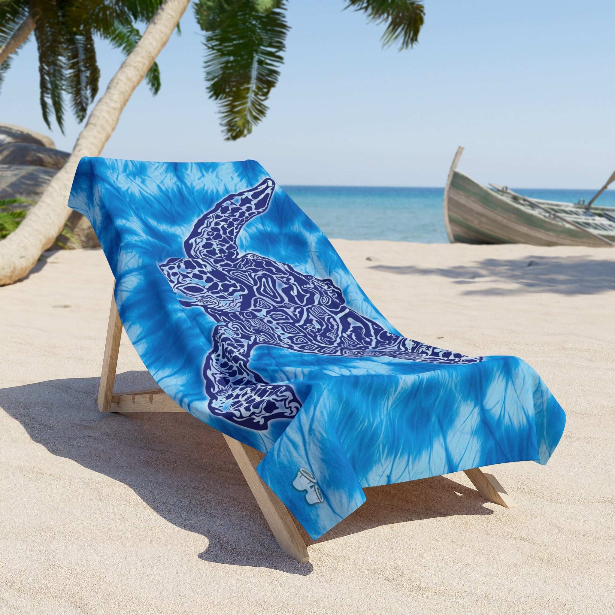Tie Dye Beach Towel with Zen Sea Turtle Design draped over a lounge chair under a palm tree at the beach