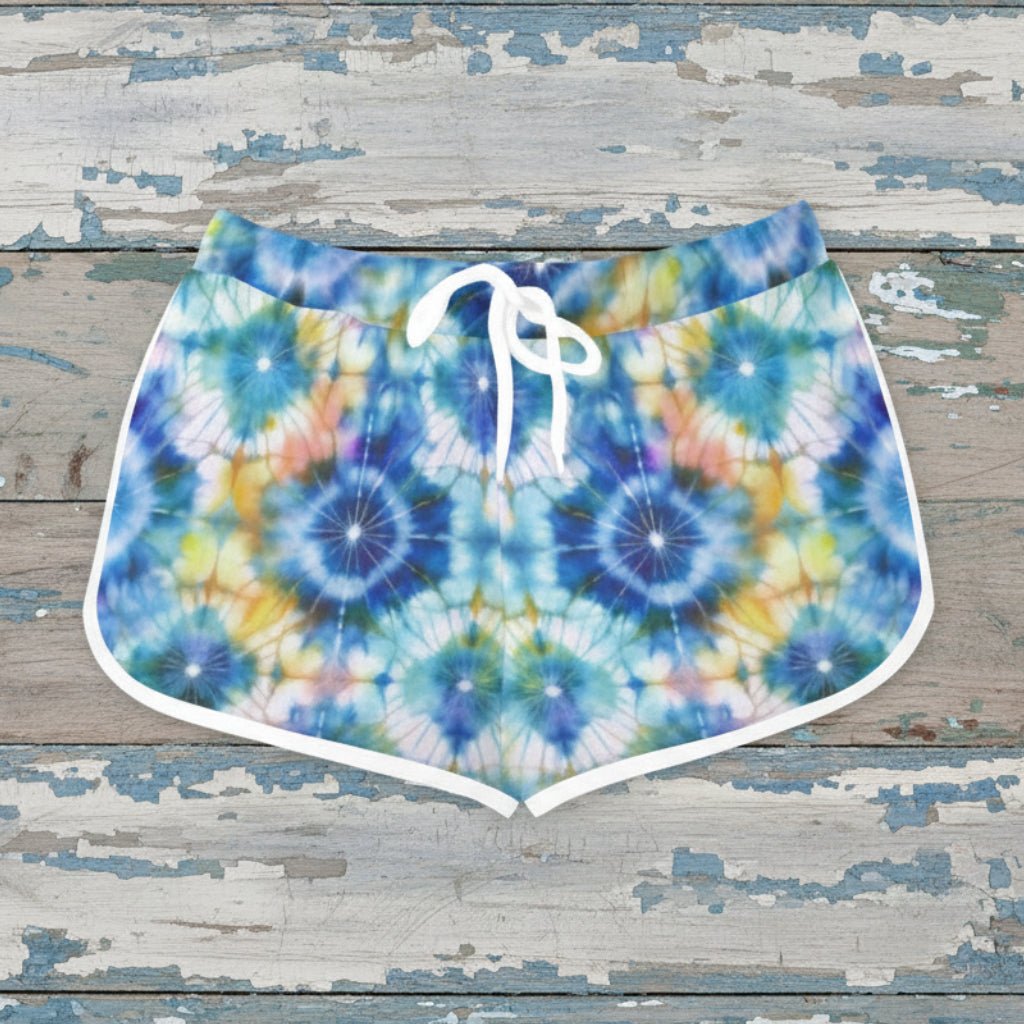 Colorful tie-dye shorts with a white drawstring on a rustic nautical wood background