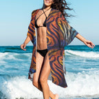 Woman in a colorful Animal Print bikini cover walking on a beach with ocean waves in the background