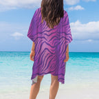 Person wearing a purple tiger print cover-up on a beach