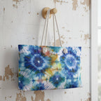 Tie-dye patterned weekender bag hanging on a wooden hook against a rustic white wall.