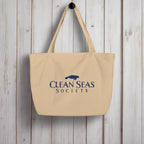 Large organic tote bag from Clean Seas Society hanging on a rustic nautical wood wall