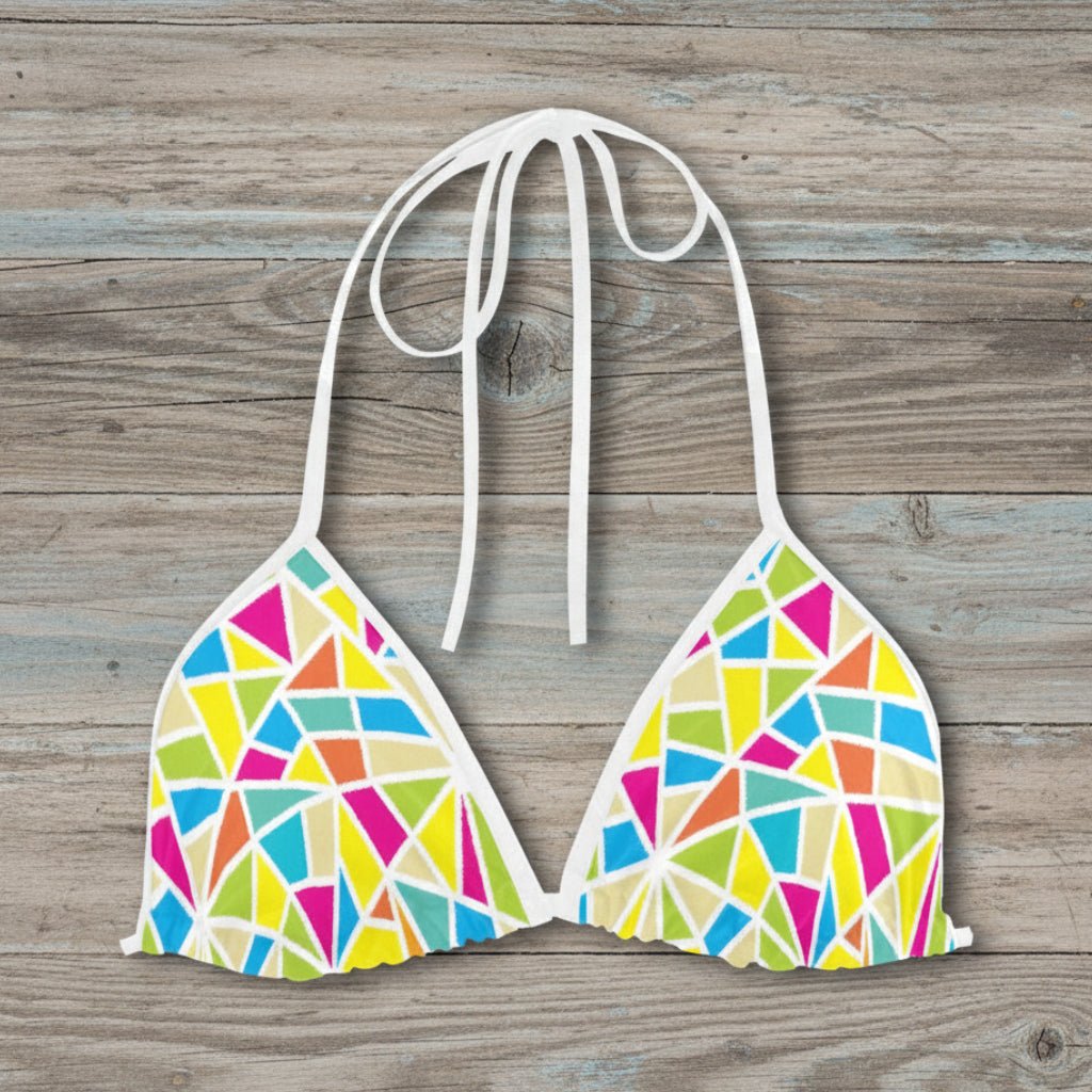 Colorful geometric-patterned bikini top on a rustic wood background