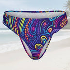 Colorful patterned swim briefs on a faded beach background
