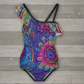 Colorful one-piece swimsuit with a vibrant pattern on a rustic wood background