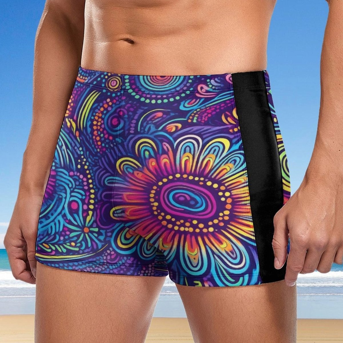 Colorful patterned swim shorts with a black side panel against a beach background