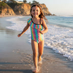 little girl wearing tropical striped Girls Ruffled Swimsuit with ruffled details on La Jolla Beach