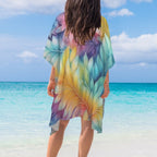 Person wearing a colorful leaf-patterned cover-up on a beach