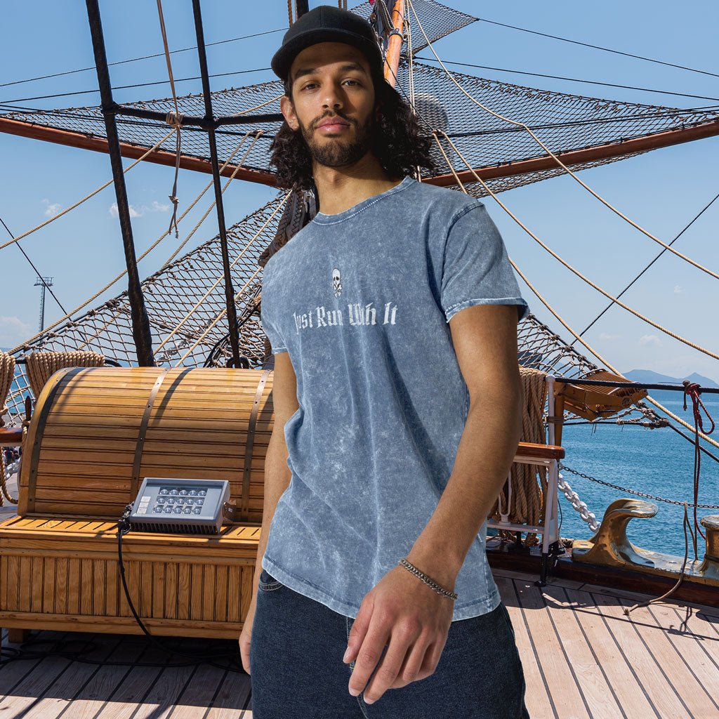 Man wearing a blue Denim Pirate T-Shirt with text on a ship deck