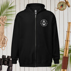 Black hoodie with a white emblem on a wooden background with nautical items.