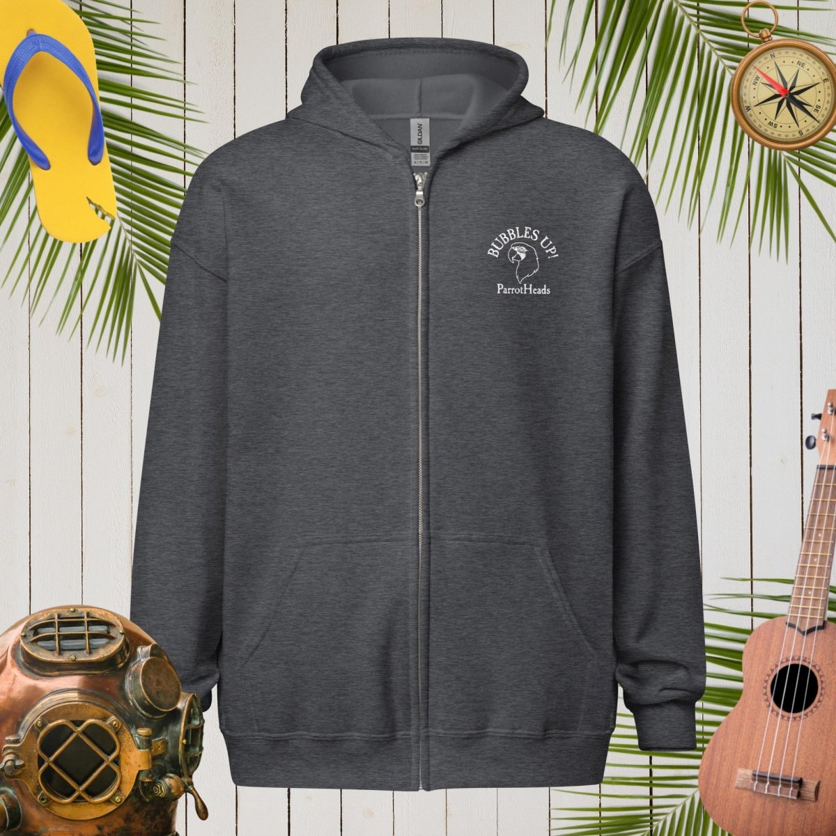 Dark gray hoodie with a logo on a wooden background with tropical elements.