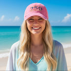 Pink cap with 'United States 250 of America' text and American flag design on a cute blond girl standing on Miami Beach