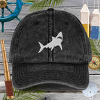 Black cap with shark design on a wooden background with nautical items