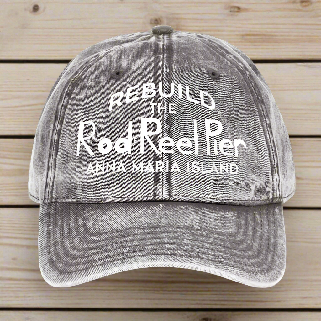 Gray cap with white text 'REBUILD THE Rod & Reel Pier Anna Maria Island' on a wood background