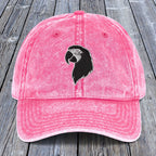 Pink cap with a black parrot design on a wooden surface