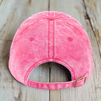 Pink baseball cap on a wooden surface