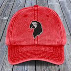 Red cap with a black and white logo on a wooden surface