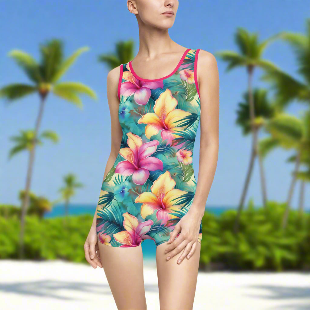 Hawaiian Style One Piece Vintage Swimsuit with Floral Pattern and Hot Pink Trim worn by a swimwear model on the beach