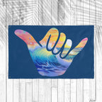 Colorful 'shaka' hand sign with ocean wave design on a blue background
