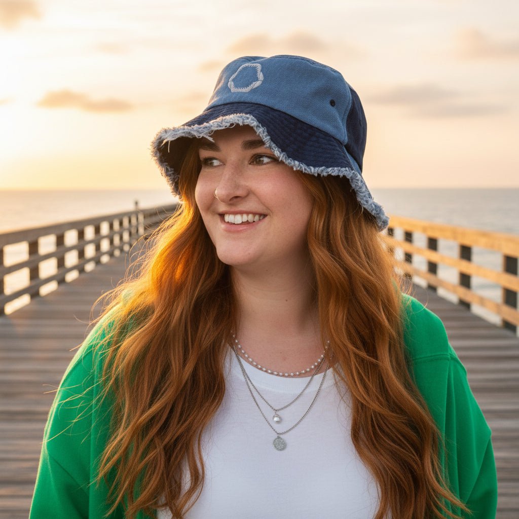 woman wearing a blue bucket hat with embroidered white shark jaws standing on a fishing pier
