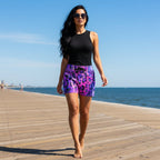 beautiful woman with long flowing black hair walking along the Atlantic City Boardwalk wearing purple and pink leopard print shorts