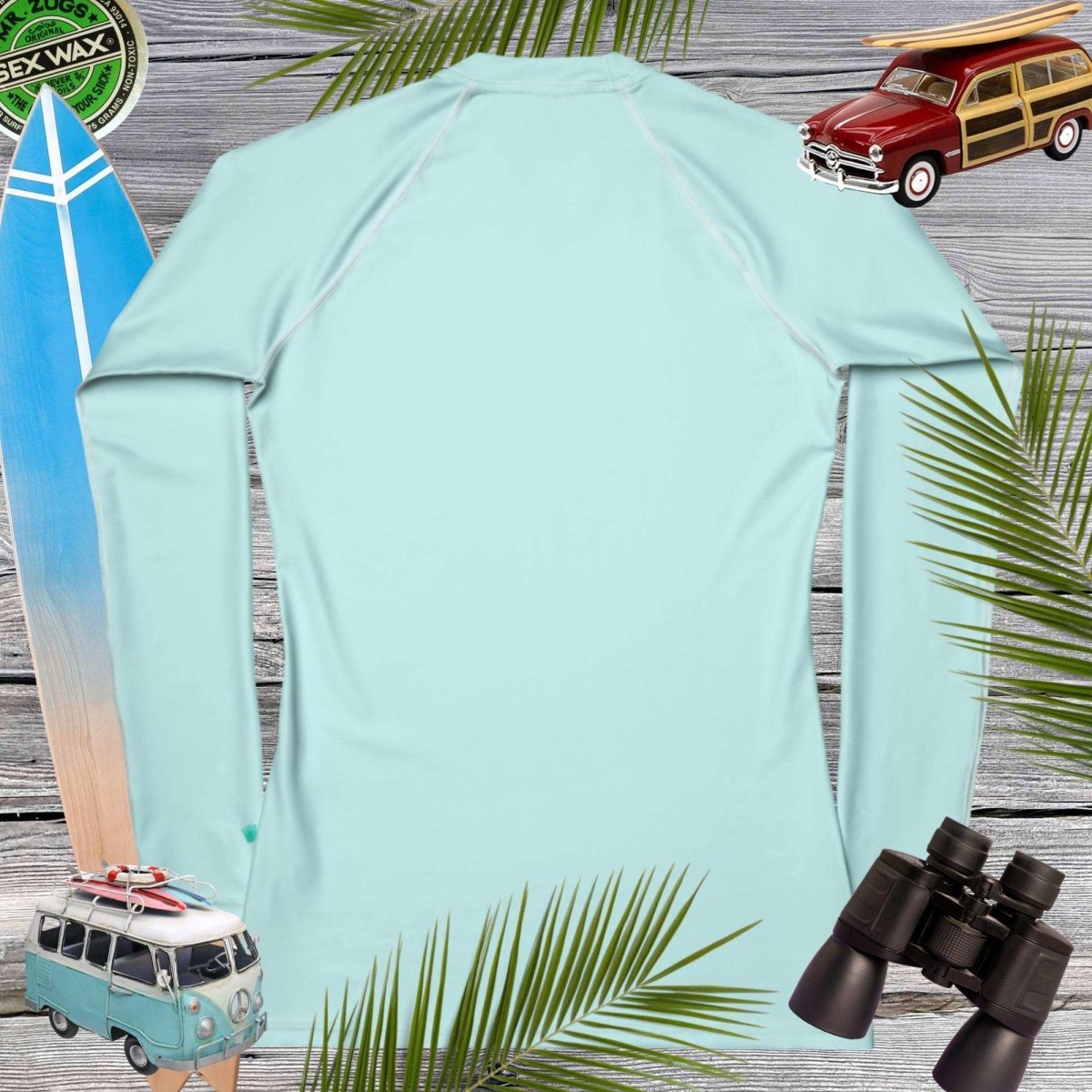 Light blue sun shirt with vintage car, surfboard, and binoculars on a wooden background