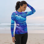 Woman wearing a blue and purple wave-patterned long-sleeve shirt on a faded beach background