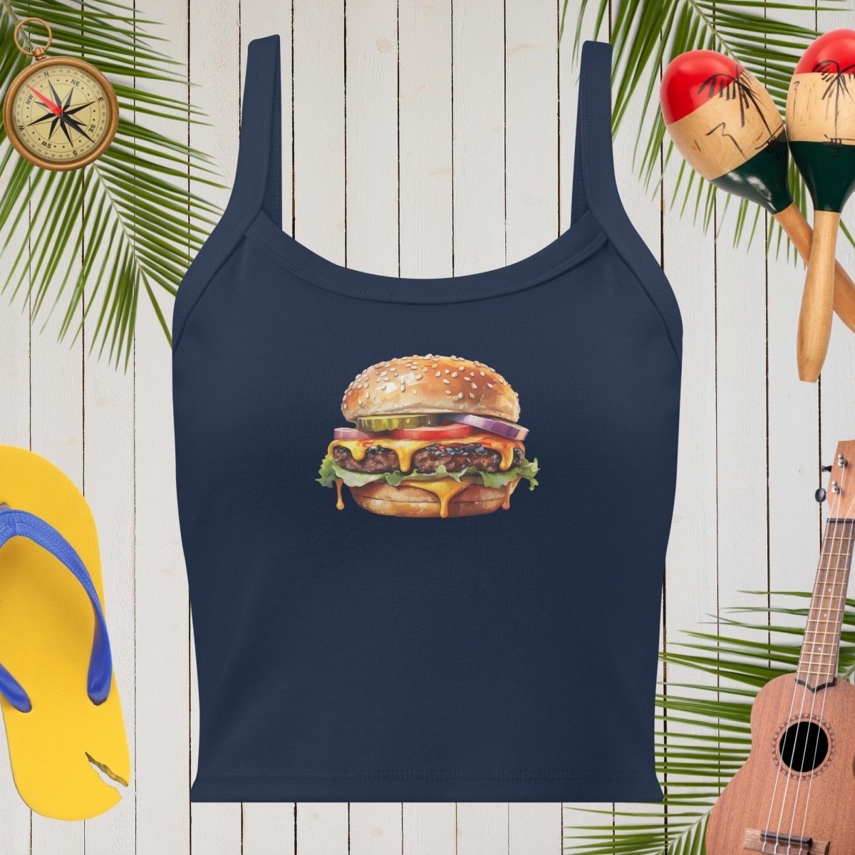 Navy blue tank top with a hamburger graphic on a wooden background with tropical elements.