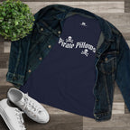 A navy blue graphic t-shirt with 'Pirate Pillows' and skull-and-crossbones text, styled in a flat lay with an open dark denim jacket, white sneakers, and a small green plant on a wood plank background.
