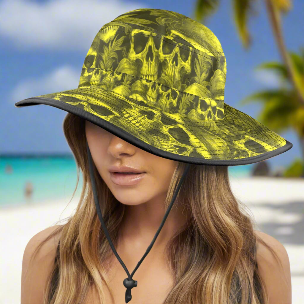 Woman wearing a yellow and black skull-patterned bucket hat on a caribbean beach background